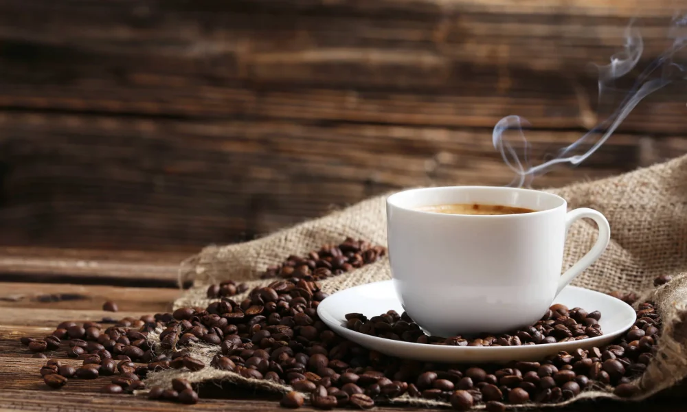 steamingcupofcoffeewithspiltcoffeebeans.jpg