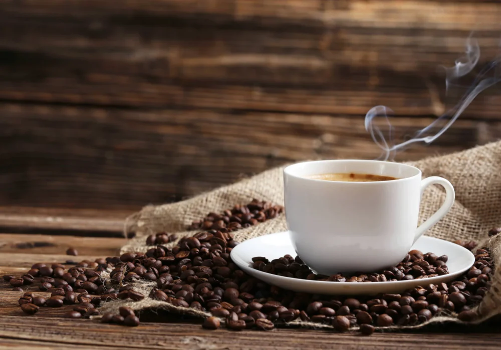 steamingcupofcoffeewithspiltcoffeebeans.jpg